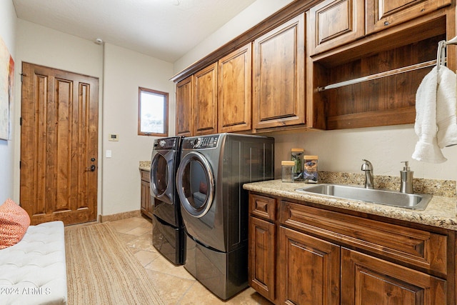 laundry room with washer and clothes dryer, sink, light tile patterned floors, and cabinets