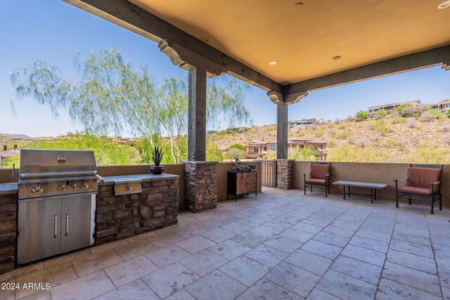 view of patio / terrace featuring a mountain view, grilling area, and exterior kitchen