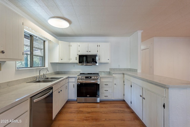 923 N Easy St, Payson, AZ 85541 - kitchen featuring ornamental molding, a peninsula, stainless steel appliances, light wood finished floors, and a sink