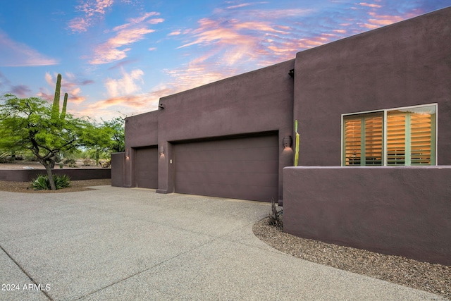 property exterior at dusk featuring a garage