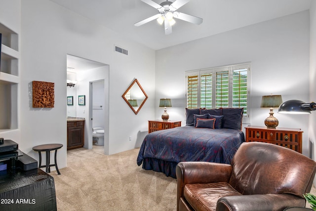 bedroom with connected bathroom, ceiling fan, and light colored carpet