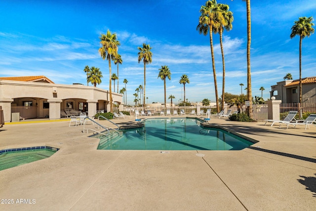 community pool with a patio and fence