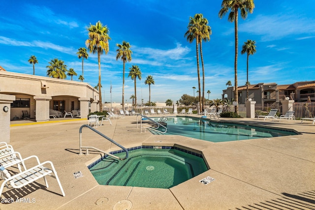 community pool featuring a patio area, fence, and a community hot tub