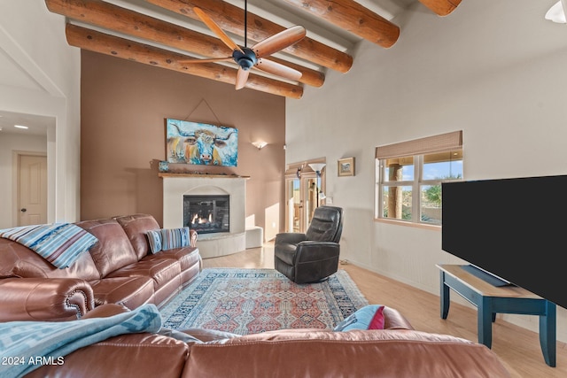 living room with beam ceiling, ceiling fan, and light hardwood / wood-style floors