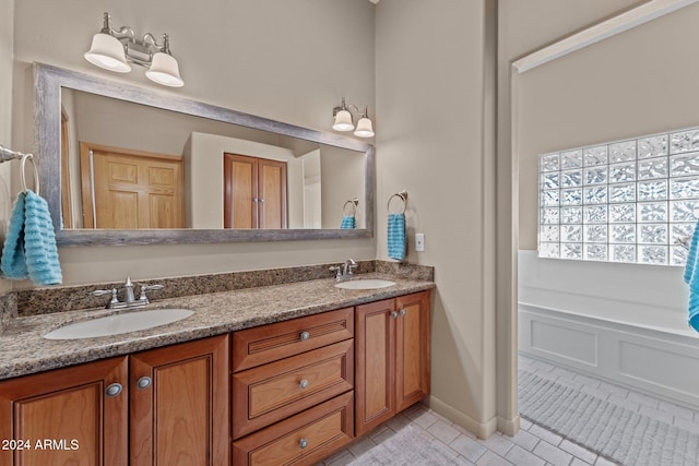 bathroom with tile patterned floors, a washtub, and vanity