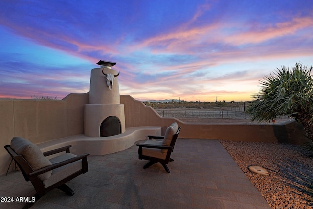 patio terrace at dusk with exterior fireplace