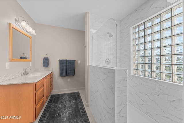 bathroom with tiled shower and vanity