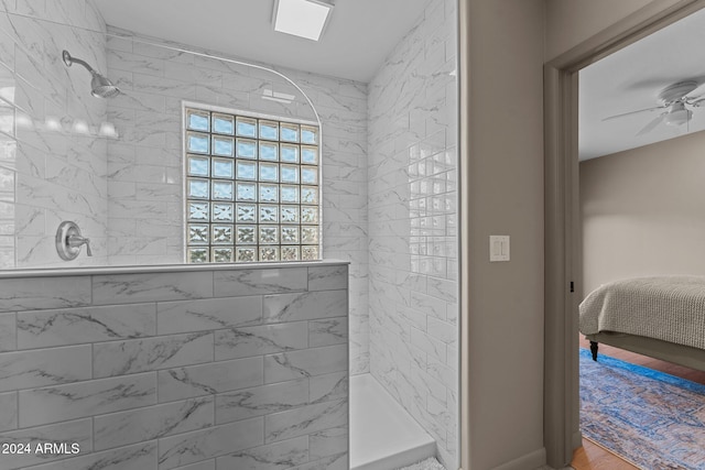 bathroom featuring ceiling fan, wood-type flooring, and tiled shower