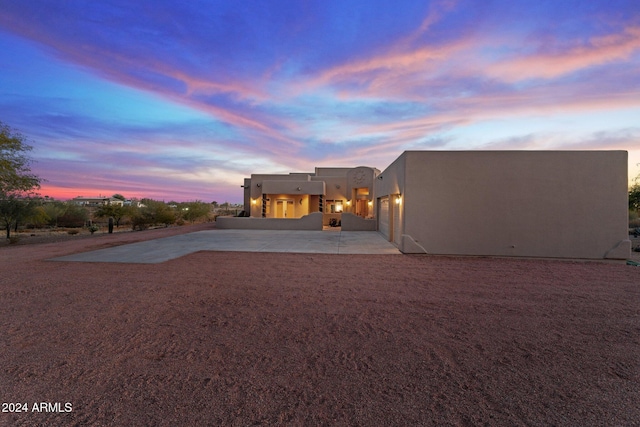 back house at dusk with a patio