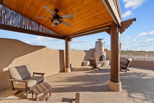 view of patio / terrace featuring ceiling fan and an outdoor fireplace