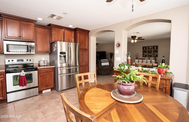 2101 S Meridian Rd Unit 176, Apache Junction, AZ 85120 - kitchen with stainless steel appliances, ceiling fan, arched walkways, light tile patterned floors, and light countertops