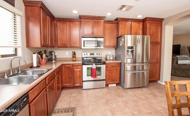 2101 S Meridian Rd Unit 176, Apache Junction, AZ 85120 - kitchen with appliances with stainless steel finishes, a sink, arched walkways, light countertops, and brown cabinetry