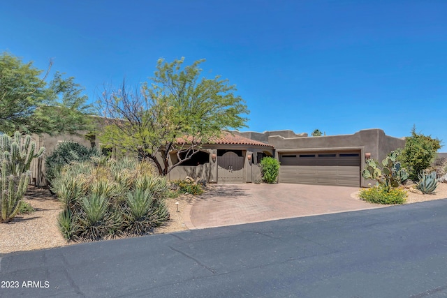 pueblo revival-style home featuring a garage