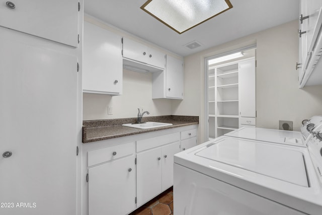 washroom featuring cabinets, sink, and washing machine and clothes dryer