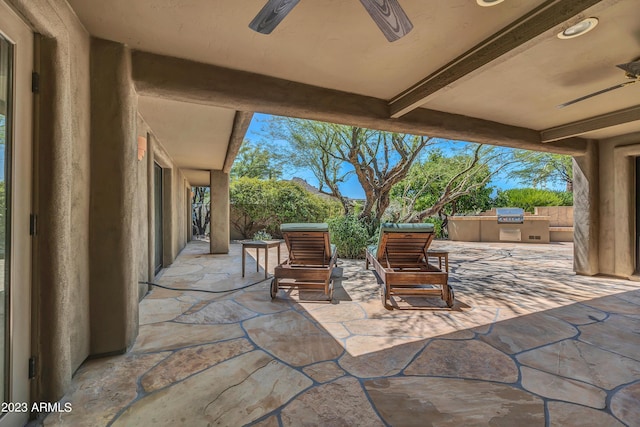 view of patio with an outdoor kitchen, area for grilling, and ceiling fan