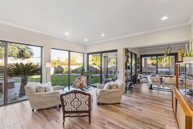 living room featuring crown molding, a wealth of natural light, and light hardwood / wood-style flooring