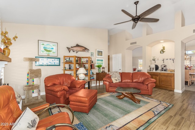 living room featuring wood-type flooring, ceiling fan, and high vaulted ceiling