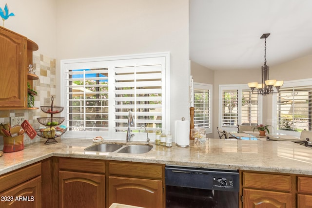 kitchen with sink, a chandelier, hanging light fixtures, dishwasher, and light stone countertops