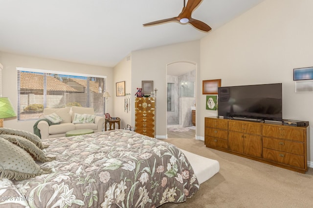 bedroom with ceiling fan, ensuite bath, vaulted ceiling, and light carpet