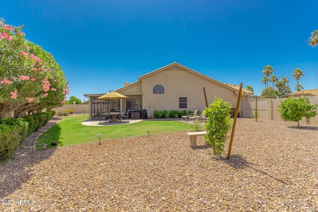 back of house with a yard and a patio