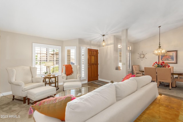 carpeted living room with lofted ceiling and a chandelier