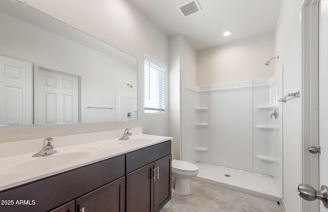 bathroom with vanity, toilet, tile patterned floors, and walk in shower