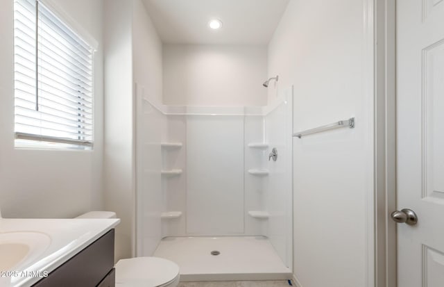 bathroom featuring a shower, vanity, and toilet