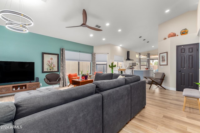 living room with ceiling fan with notable chandelier and light wood-type flooring