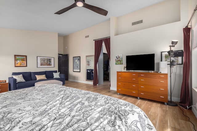 bedroom featuring ceiling fan, high vaulted ceiling, and light hardwood / wood-style flooring