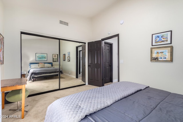 carpeted bedroom with high vaulted ceiling and a closet