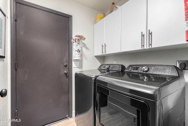 washroom with cabinets, independent washer and dryer, and light hardwood / wood-style flooring