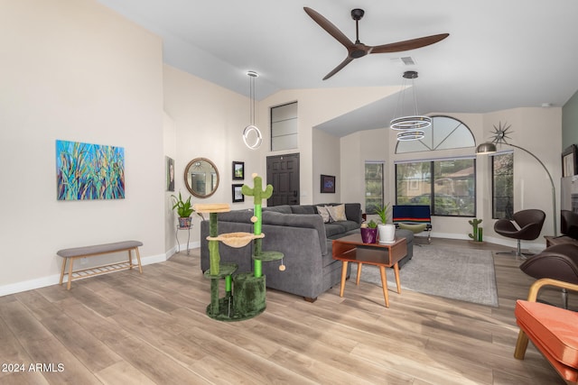 living room with ceiling fan, light hardwood / wood-style floors, and high vaulted ceiling