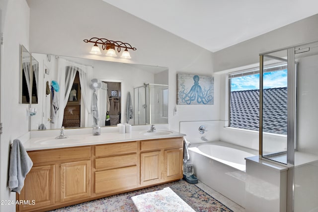 bathroom with vanity, vaulted ceiling, and independent shower and bath