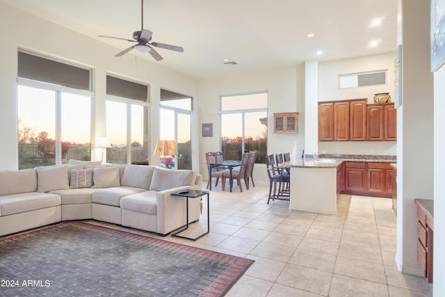 living room with sink, ceiling fan, and light tile patterned flooring