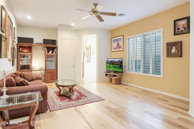 living room with ceiling fan and light hardwood / wood-style flooring