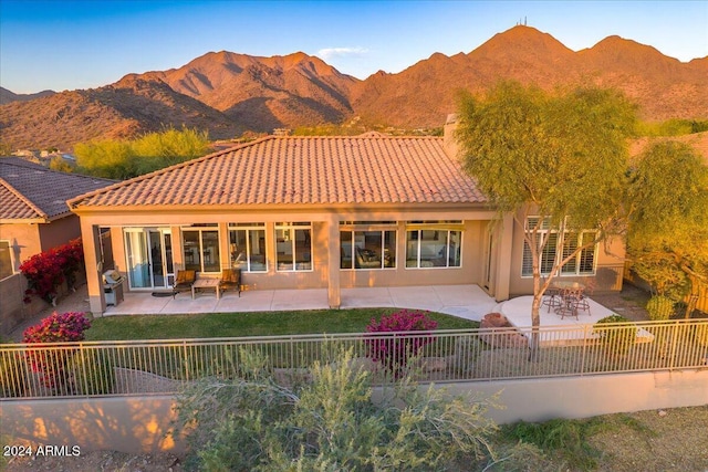 rear view of property featuring a mountain view and a patio