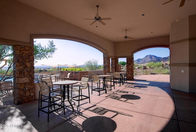 view of patio featuring ceiling fan and a mountain view