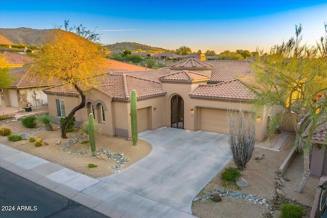 mediterranean / spanish-style home featuring a mountain view and a garage