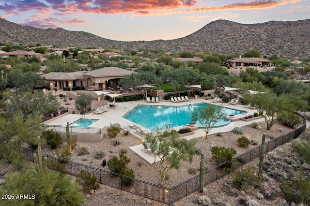 pool at dusk with a mountain view and a patio area