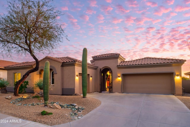 mediterranean / spanish home featuring a garage