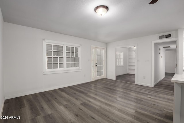 empty room with a textured ceiling and dark hardwood / wood-style floors