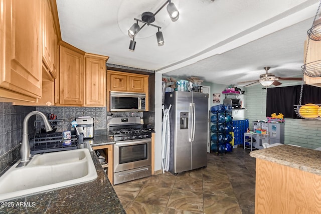 kitchen with sink, a textured ceiling, ceiling fan, stainless steel appliances, and decorative backsplash