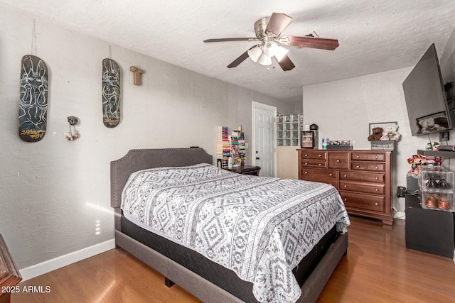 bedroom with hardwood / wood-style flooring, a textured ceiling, and ceiling fan