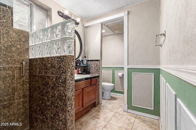 bathroom with tile patterned flooring, vanity, an enclosed shower, toilet, and a textured ceiling