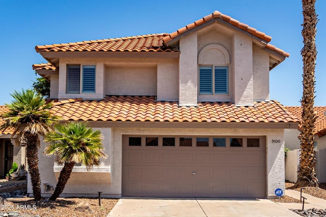 9100 E Captain Dreyfus Ave, Scottsdale, AZ 85260 - mediterranean / spanish-style house featuring an attached garage, a tiled roof, driveway, and stucco siding