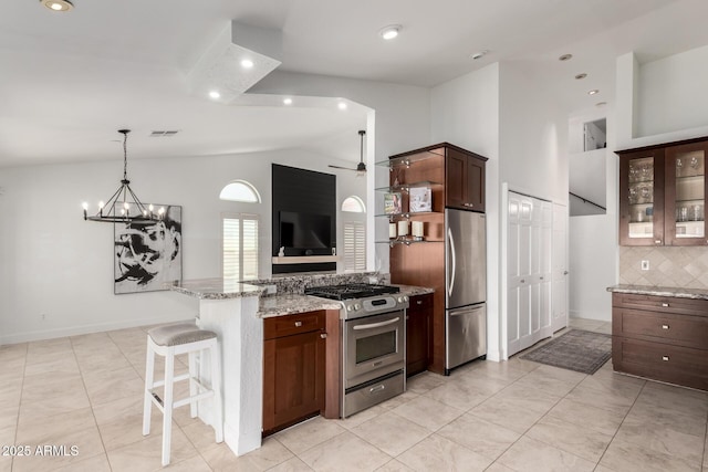 9100 E Captain Dreyfus Ave, Scottsdale, AZ 85260 - kitchen featuring stainless steel appliances, vaulted ceiling, decorative backsplash, a peninsula, and light stone countertops