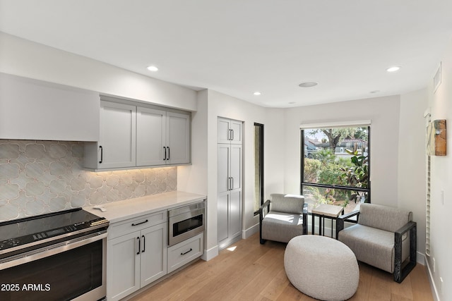 kitchen featuring decorative backsplash, stainless steel appliances, and light hardwood / wood-style floors