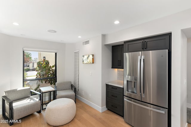 kitchen featuring stainless steel fridge and light hardwood / wood-style floors