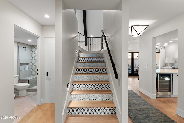 stairs with wine cooler and wood-type flooring