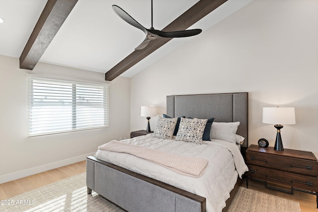 bedroom featuring vaulted ceiling with beams, light hardwood / wood-style flooring, and ceiling fan